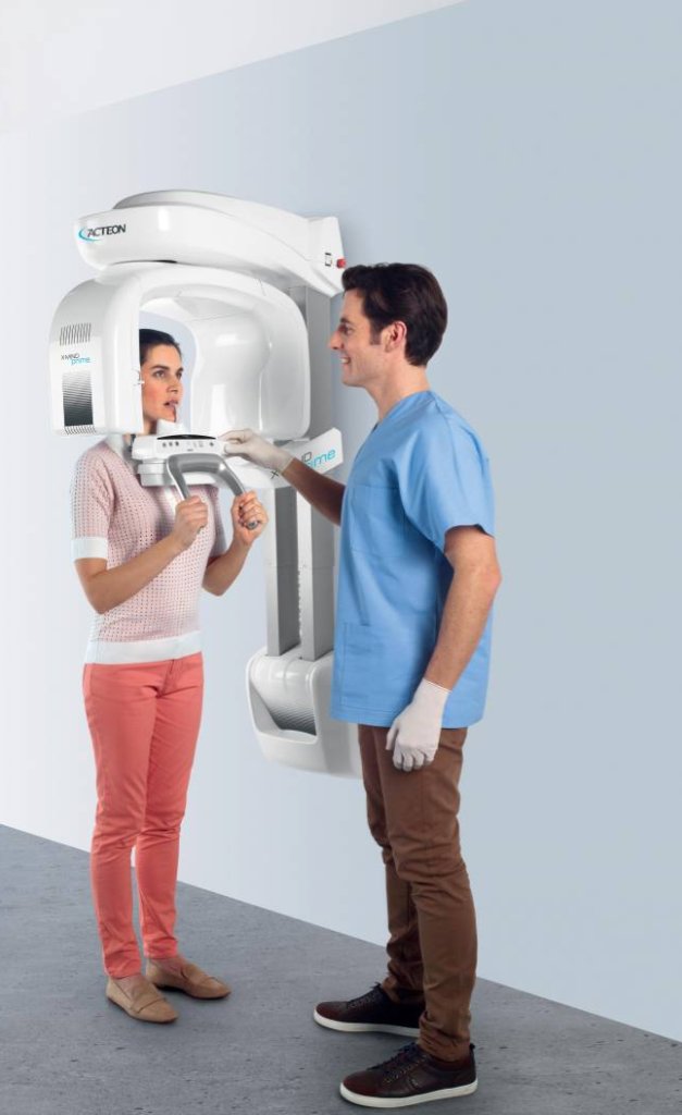 A dentist taking an x-ray of a patient's jaw using the Acteon X Mind Prime digital dental scanner